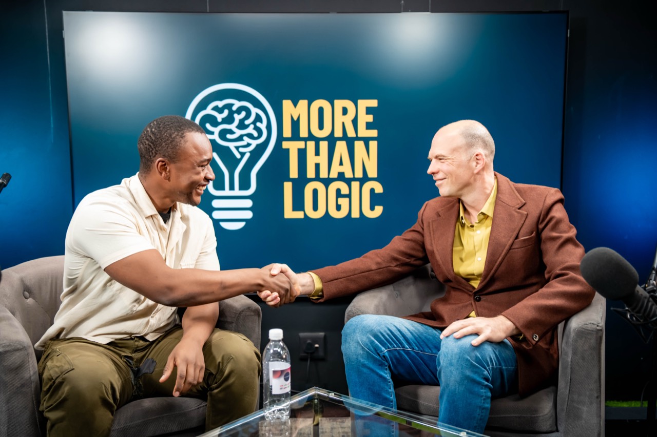 Host and guest shaking hands on the More Than Logic podcast set