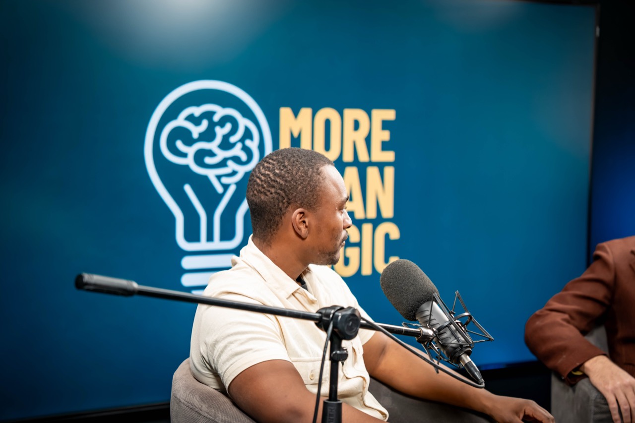 A More Than Logic podcast recording, two microphones and the show’s logo wall