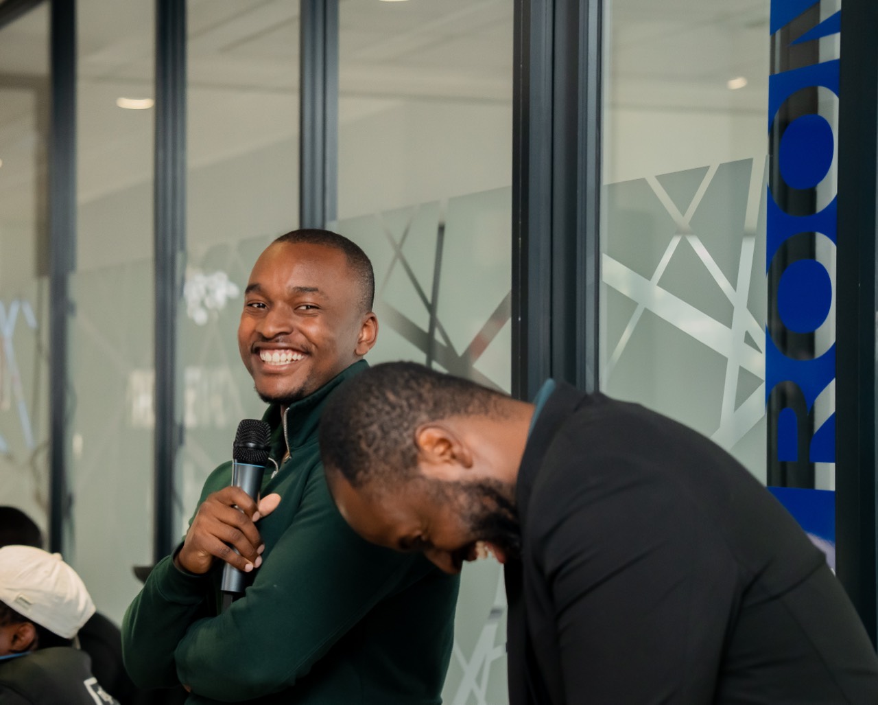 A speaker laughing with a microphone at a NIFA Academy event
