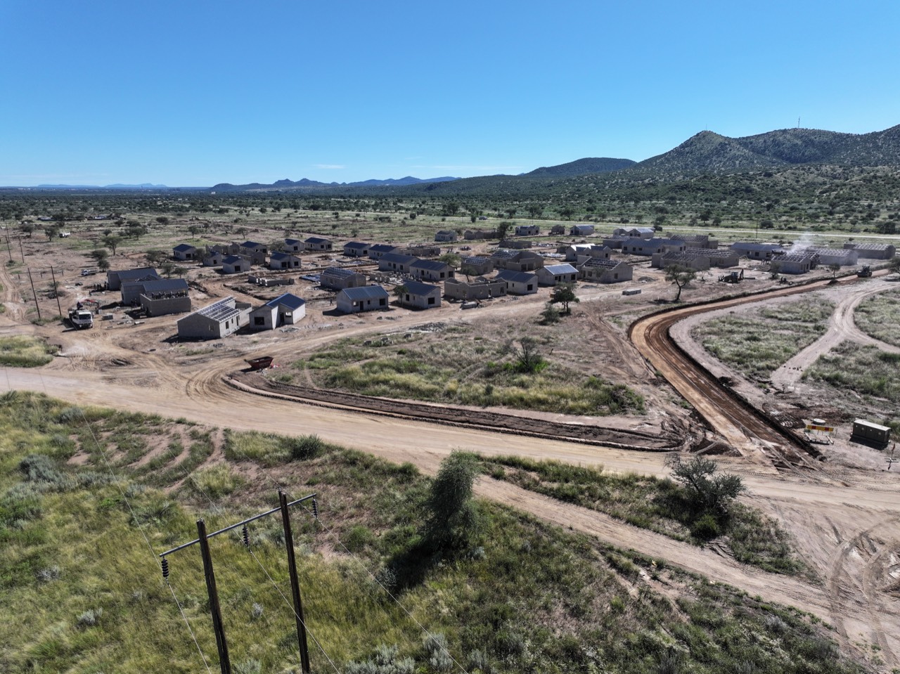 Aerial view of a new Okamita Properties neighbourhood with hills behind
